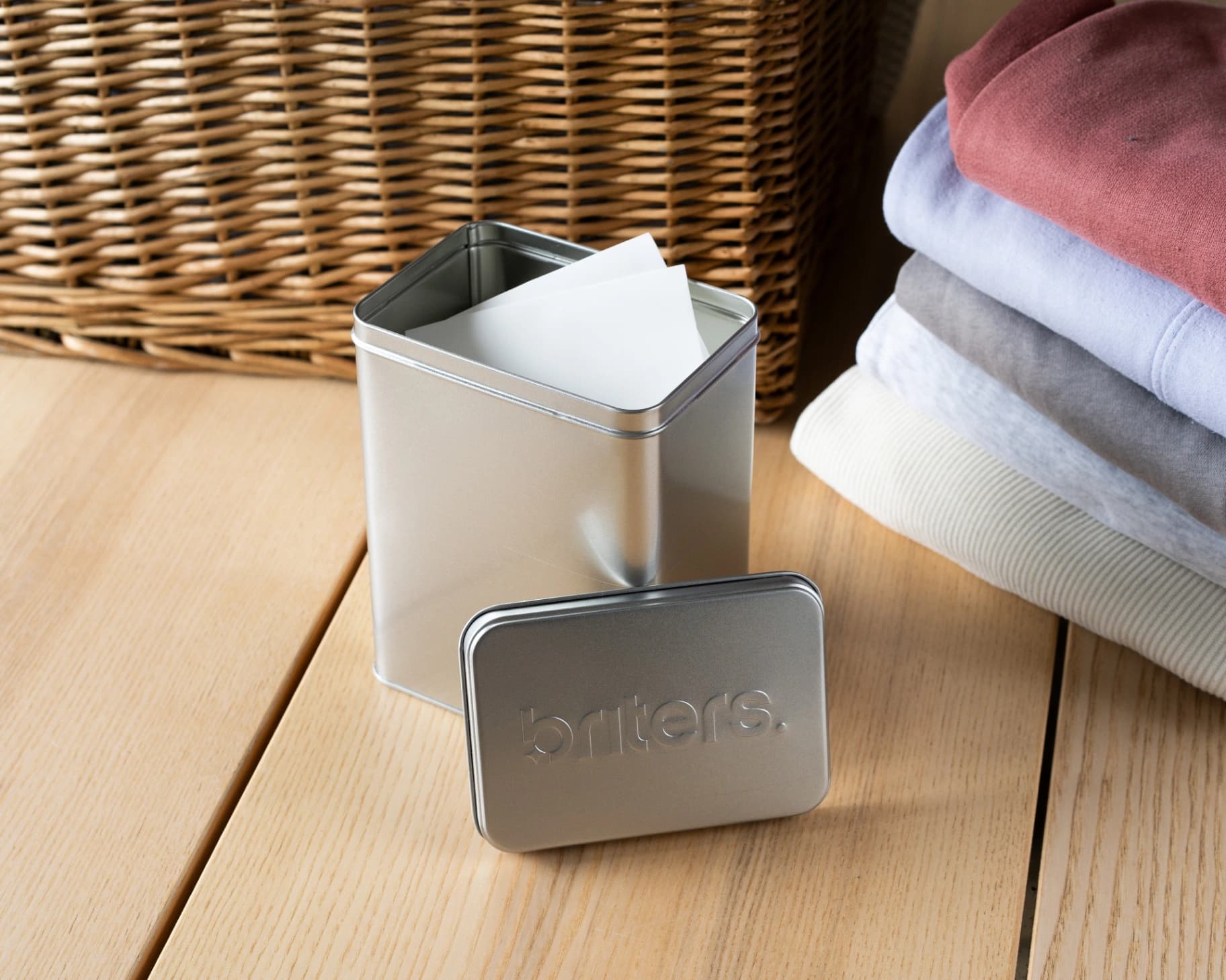 Briters bewaarblik naast gestapelde kleding en rieten mand